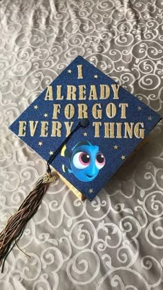 a blue graduation cap with the words i already forgot everything on it and an image of stitched eyes