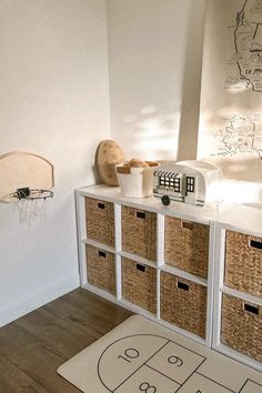 a basketball court rug is on the floor next to a white cabinet with baskets in it