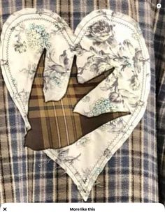 a close up of a person's shirt with a heart shaped patch on it