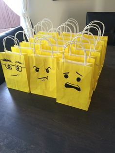 yellow bags with faces drawn on them sitting on a table