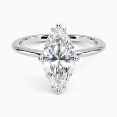 an oval cut diamond engagement ring on a white background