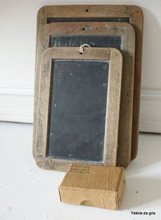 an old chalkboard with a wooden box underneath it