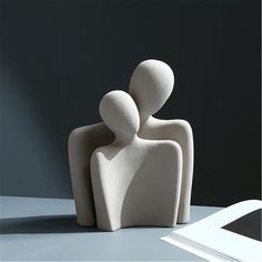 two white sculptures sitting next to each other on a table