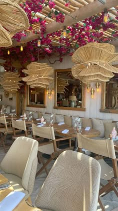 the interior of a restaurant with tables and chairs covered in wicker umbrellas hanging from the ceiling