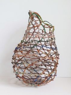 a sculpture made out of beads and wire on a white surface with no one in it