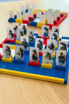 legos are arranged in rows to form a table with pictures on it and people sitting around them