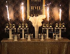 a table topped with lots of white vases and candles