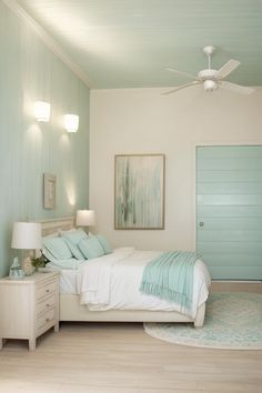 a bed room with a neatly made bed and a ceiling fan