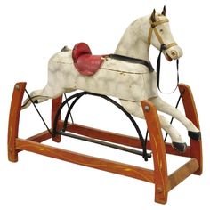 an old fashioned rocking horse with a red hat on it's head and tail