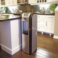 a modern kitchen with white cabinets and black counter tops, along with an island in the middle