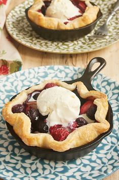 two pies with ice cream on them sitting on top of blue and white plates