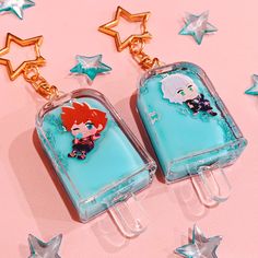 two popsicles with little mermaids on them are sitting next to star shaped stars