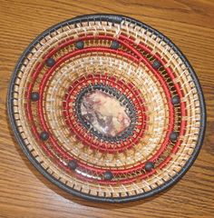 a bowl that is on top of a wooden table with red and black trimmings