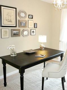 a black table with white chairs and pictures on the wall