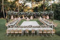 an outdoor table set up with flowers and greenery for a wedding reception at the park