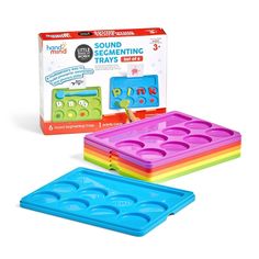 three plastic trays with different shapes and colors on them, one in the shape of an ice tray