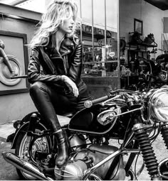 black and white photograph of a woman sitting on a motorcycle with other motorcycles in the background