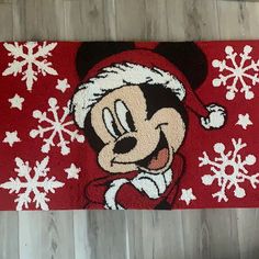 a mickey mouse door mat with snowflakes and santa hat on it's head