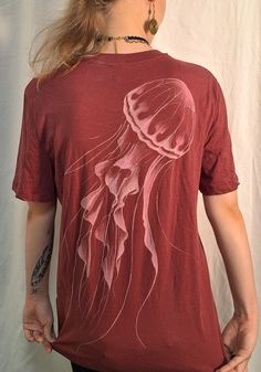 a woman wearing a red shirt with a jellyfish on it's chest and back