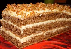 a large piece of cake sitting on top of a red plate with white frosting