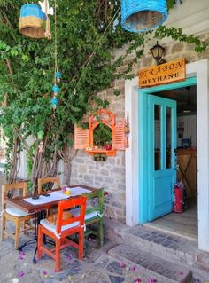 an outdoor dining area with tables, chairs and potted plants on the outside wall