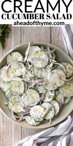 a bowl filled with cucumbers and onions on top of a table next to a napkin