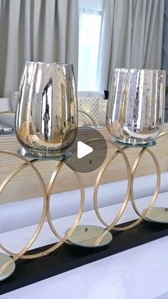 three wine glasses sitting on top of each other in front of a mirror with gold rims