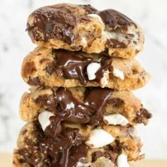 three cookies with chocolate and marshmallows stacked on top of eachother