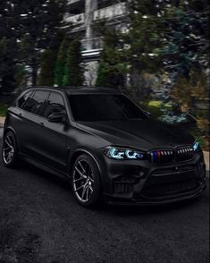 a black bmw suv parked in front of a building