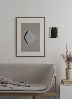 a living room with a couch, table and pictures on the wall above it that have been placed together