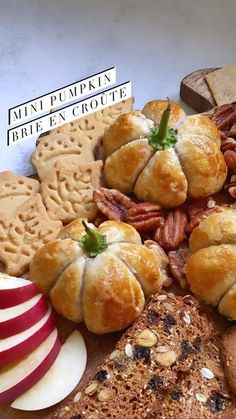 a wooden board topped with lots of different types of breads and pastries on top of each other