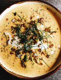 a bowl filled with soup and garnished with green sprigs on top