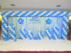 a birthday party setup with balloons and streamers on the stage for guests to sit down