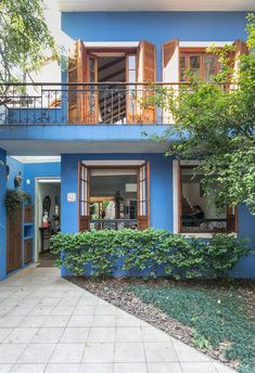 a blue building with wooden balconies on the second floor and balcony above it