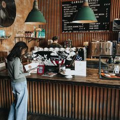 a woman standing in front of a counter at a coffee shop