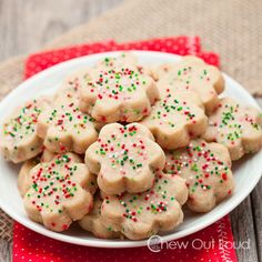 a plate full of sugar cookies with sprinkles on it and a red napkin