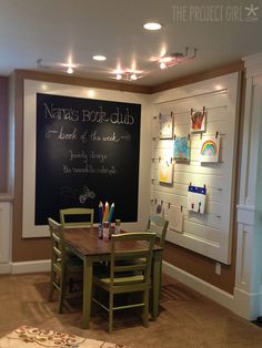 a chalkboard in the corner of a room next to a dining table and chairs