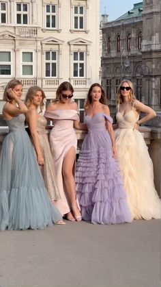 four women in dresses posing for the camera