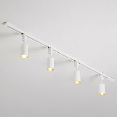 five lights are hanging from the ceiling in an empty room with white walls and flooring