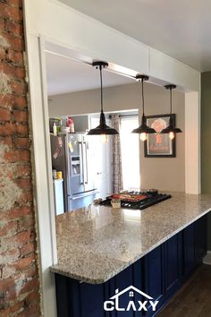 a kitchen with an island and brick wall