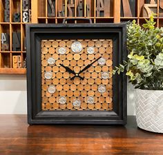 a clock made out of wine corks on a table next to a potted plant