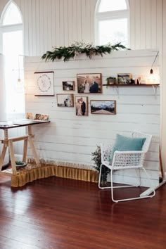 a white rocking chair sitting on top of a hard wood floor next to a window