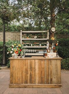 an outdoor bar with flowers and bottles on it