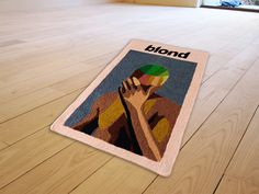 a bathroom rug with the image of a woman holding her hand to her face on a wooden floor