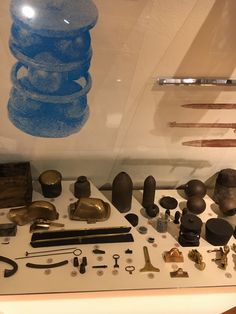 there are many different items on display in the glass case, including pipe cleaners and other tools