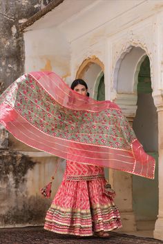 This Pink Embroidered Kurta Sharara Suit Set features a pink kurta in modal muslin silk with shibori tie-dye print and hand-embroidered detailing for an elegant and timeless look. It is paired with matching shibori sharara pants with gota embellishment along the borders as well as an organza dupatta with printed cotton fabric and gota embellishment. This set offers an exquisite look that is perfect to any special occasion. 3 piece Color: Pink Fabric: Modal Muslin Dupatta: Center Cotton, Organza Pink Semi-stitched Kurta For Traditional Ceremonies, Pink Chikankari Embroidered Dupatta In Mulmul, Pink Chikankari Embroidery Dupatta In Mulmul, Pink Sharara With Straight Kurta For Festivals, Pink Straight Kurta Sharara For Festivals, Bohemian Embroidered Pink Salwar Kameez, Bohemian Pink Embroidered Salwar Kameez, Pink Bohemian Palazzo Set For Diwali, Fitted Pink Mulmul Sets