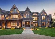 a large house with lots of windows and lights on it's front lawn area