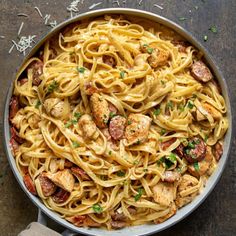 a pan filled with pasta and chicken on top of a table