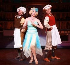 three people dressed in costumes standing on stage