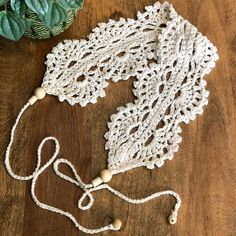 a crocheted doily next to a potted plant on a wooden table